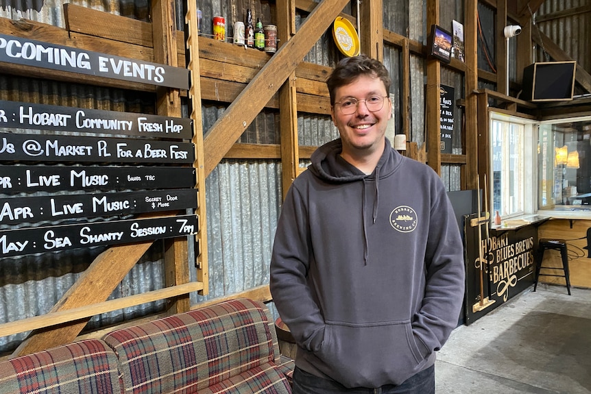 A man with glasses in a corrugated iron shed.