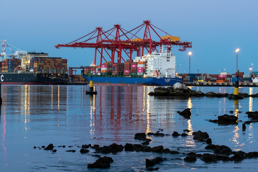 Ships on water in harbour loaded with containers.