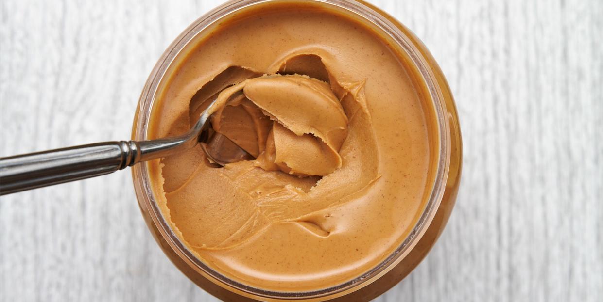 Peanut butter on spoon in jar