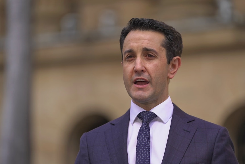 A man stands in a suit speaking.