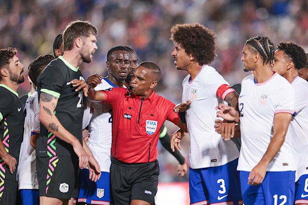 Referee Kwinsi Williams separates Cameron Burgess of Australia and Chris Richards of the United States.