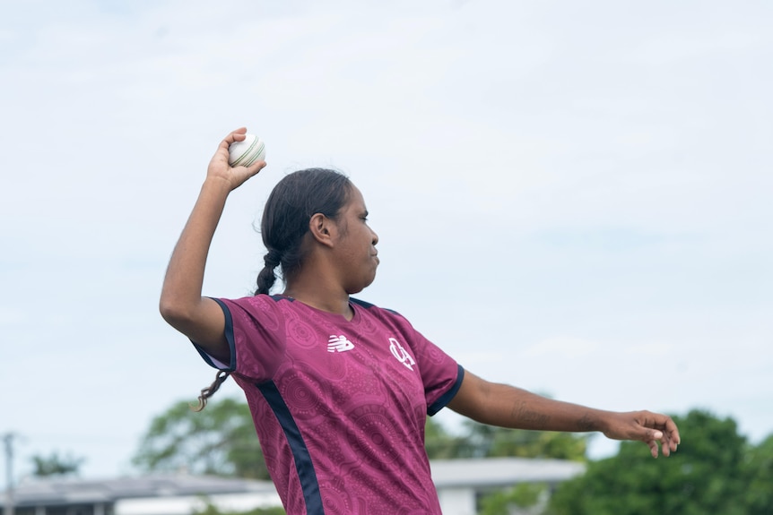 A woman bowling a cricket ball