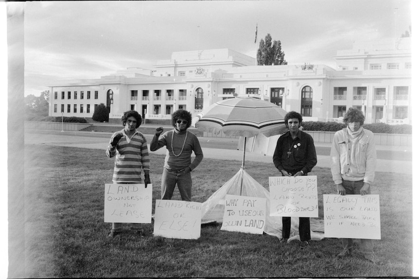 Four men in front of parliament house.