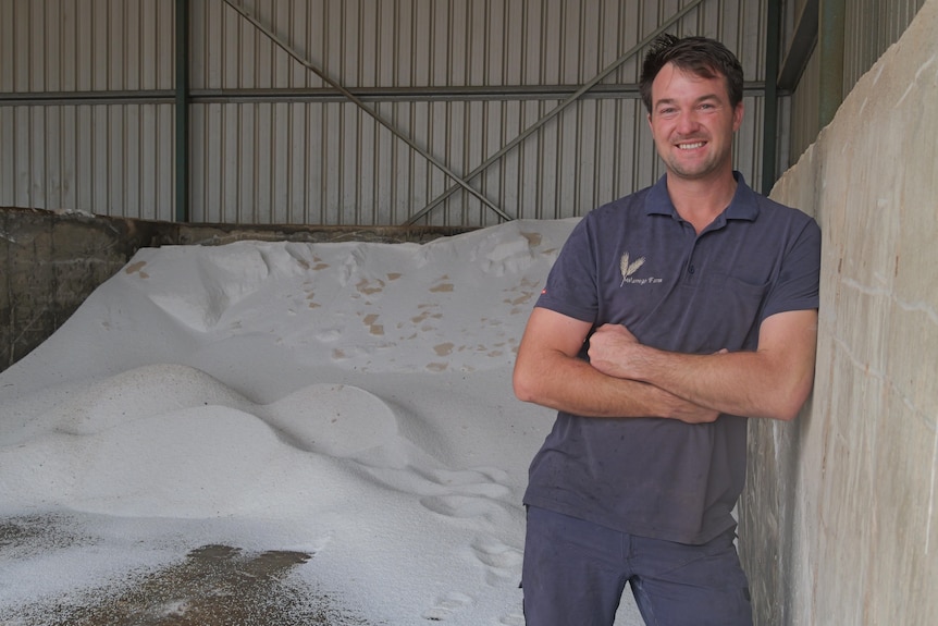 A smiling man standing in a farm shed.