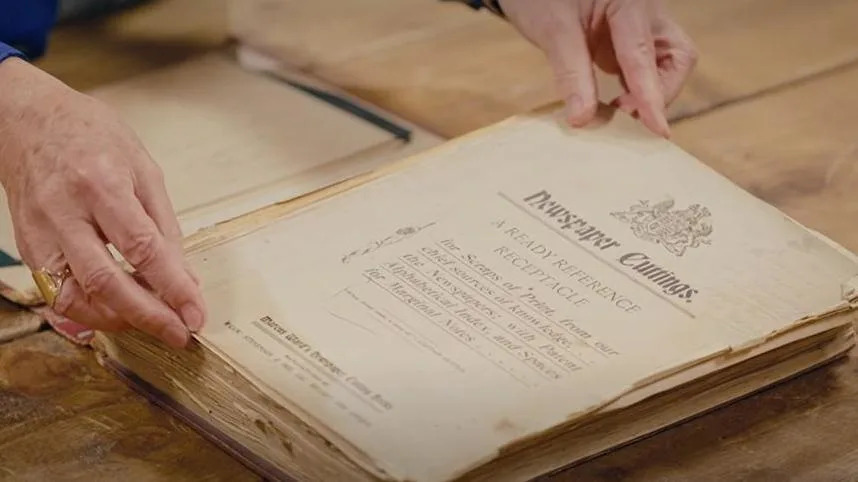 A close up of the inside of the book before its repair, showing yellowing pages that are rolling at the edges