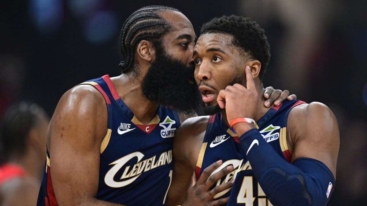 Cleveland Cavaliers guard Donovan Mitchell talking with guard James Harden on basketball court