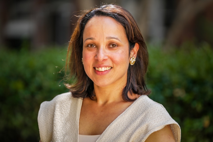 A woman smiles at the camera