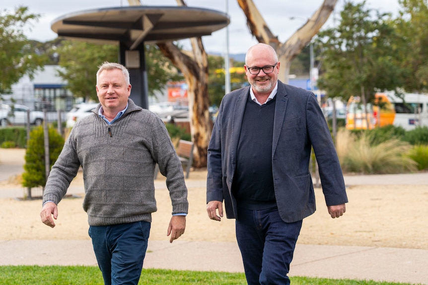 Two men talking through a park