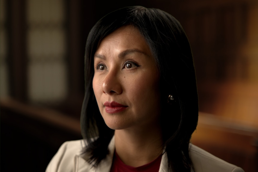 Kim looks off camera and into the distance. 