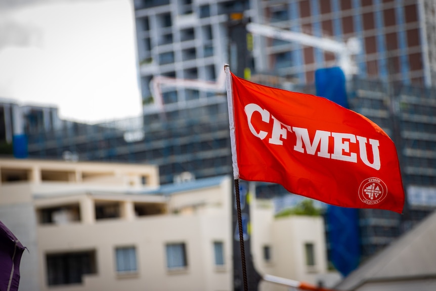 Red and black flags with the acronym CMFEU flying in the wind.