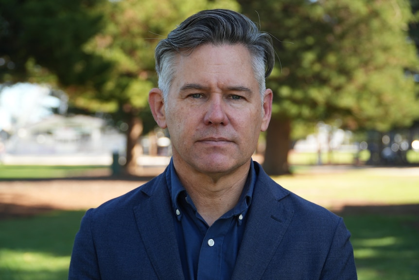 A man in a suit looking serious.