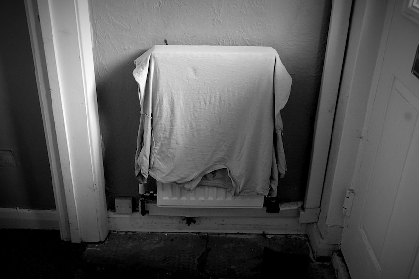 A shirt over a radiator inside a house.