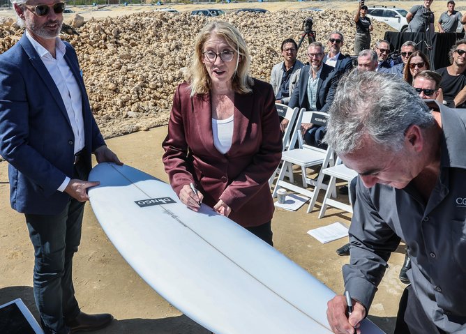 Deputy Premier Rita Saffioti signs a surfboard.
