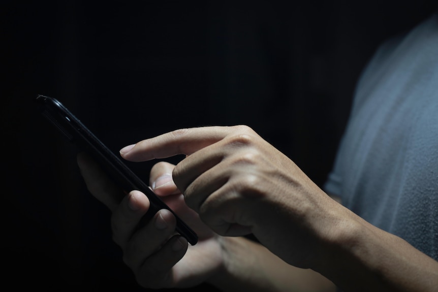 Hands holding a mobile phone.