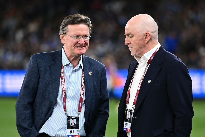Robert Priestley (left) the president of the Carlton Football Club speaks to club CEO Graham Wright (right) on the field.