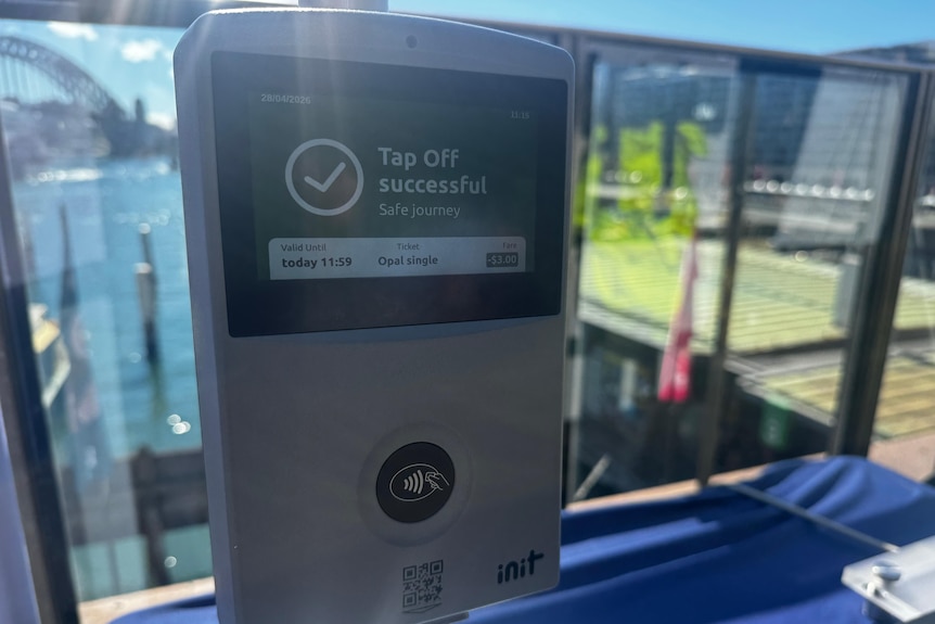 A silver rectangular machine with an icon to tap your card near at bottom with 'tap off successful' text on the screen.