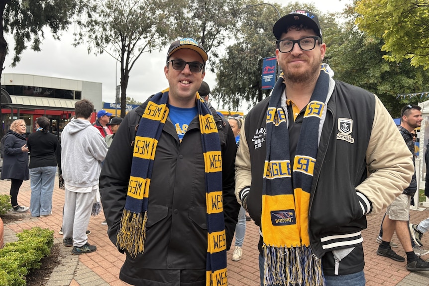 Two men with Eagles scarves on smile at the camera