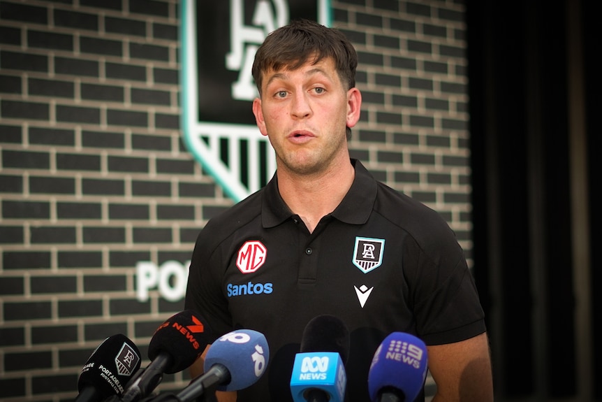 Zak Butters speaks into microphones