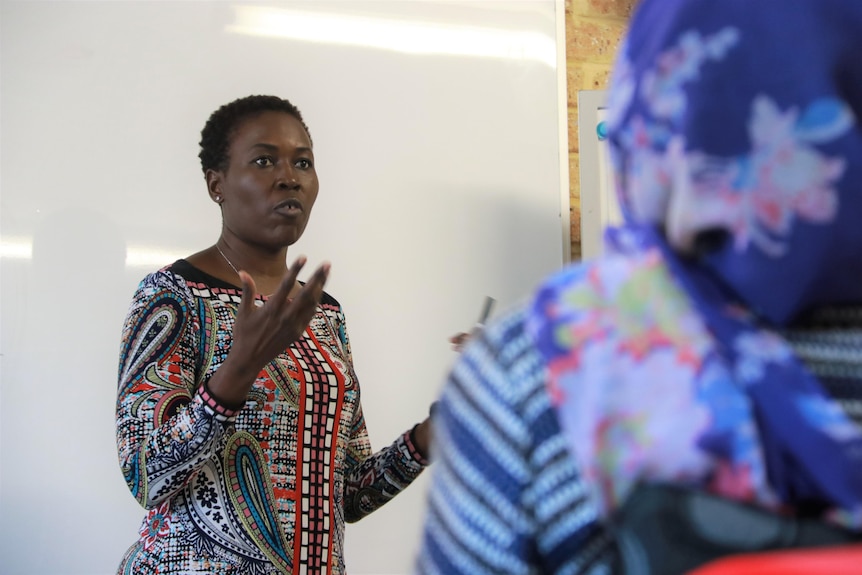Dr Barbara Nattabi talking in front of a whiteboard.