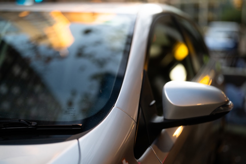 Close-up of a black windscreen wiper on a silver car