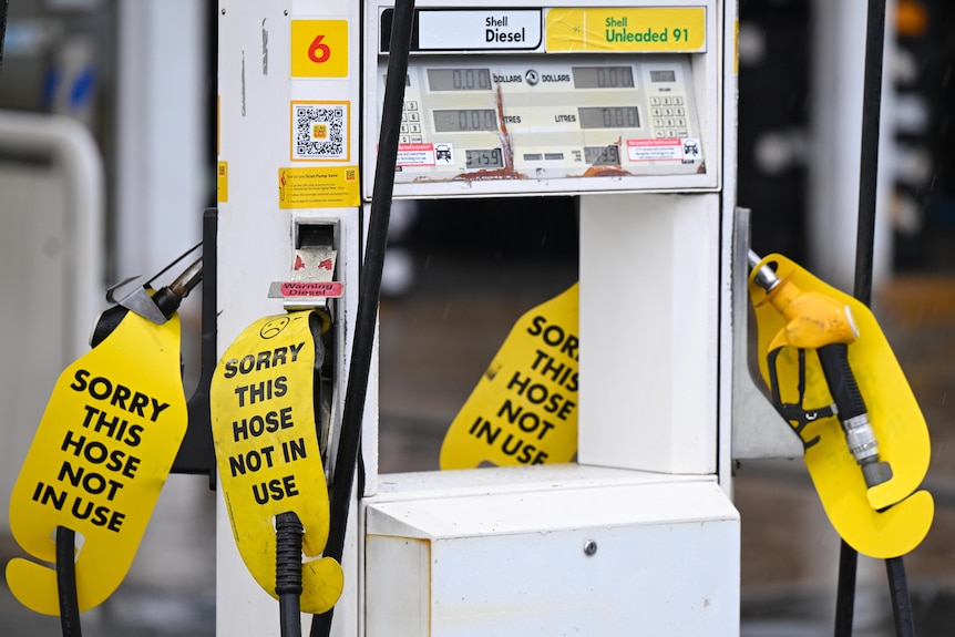 Petrol pumps with yellow tags on them. 