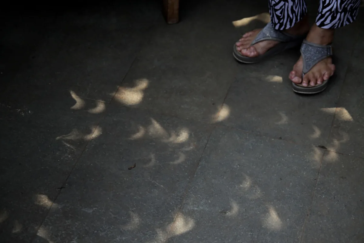 The crescent-shaped shadow of an eclipse seen on the ground as sunlight from a solar eclipse passes through gaps created by leaves on a tree, Jakarta Planetarium, Ismail Marzuki Park, Jakarta, 26 December 2019. Photo by Aditya Irawan/NurPhoto via Getty Images