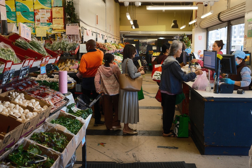 A busy fruit and vegetable store counter at Footscray markey.