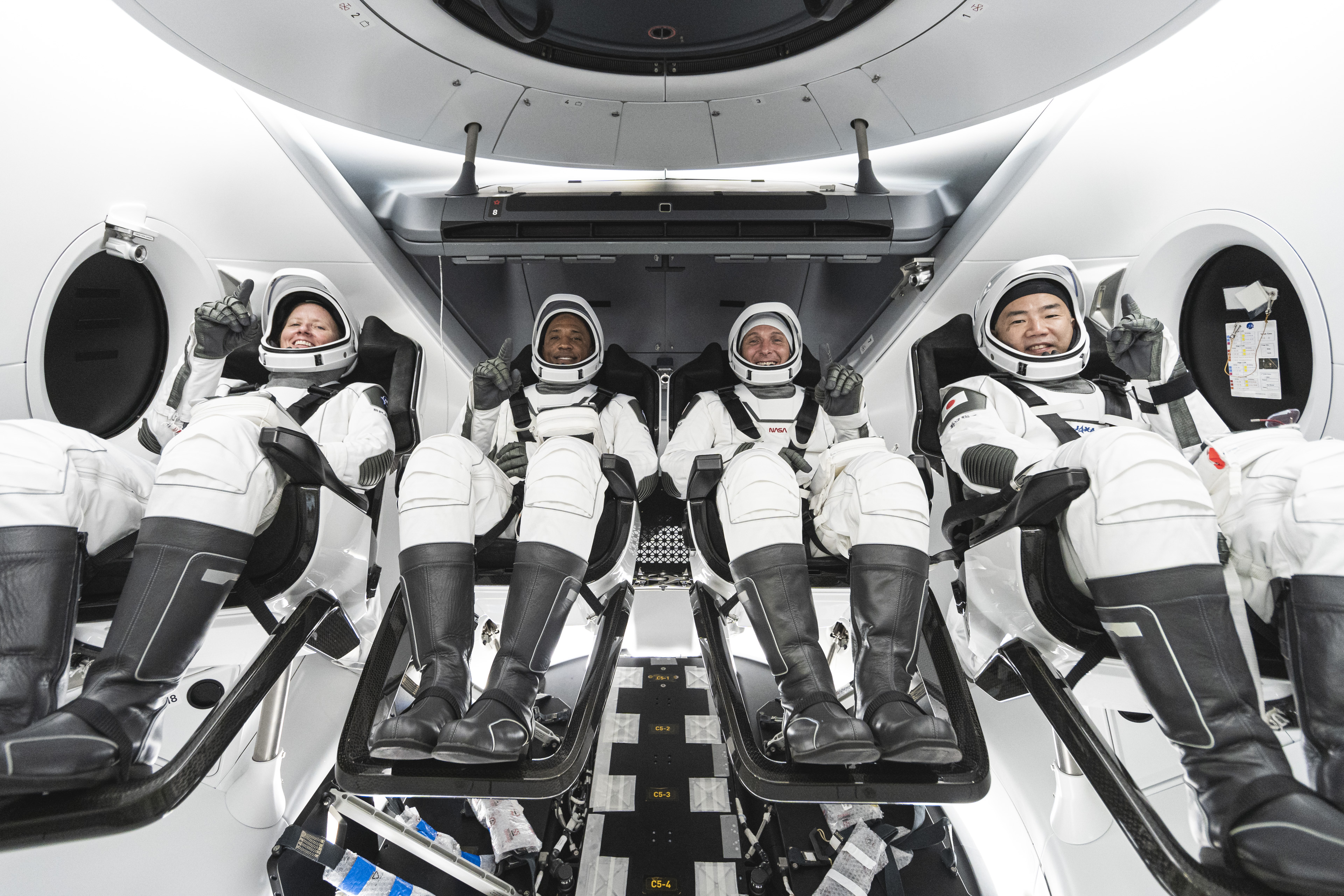 From left, Mission Specialist Shannon Walker, Pilot Victor Glover, Crew Dragon Commander Michael Hopkins &ndash; all NASA astronauts &ndash; and Japan Aerospace Exploration Agency (JAXA) astronaut and Mission Specialist Soichi Noguchi are seated in SpaceX&rsquo;s Crew Dragon spacecraft during crew equipment interface training.