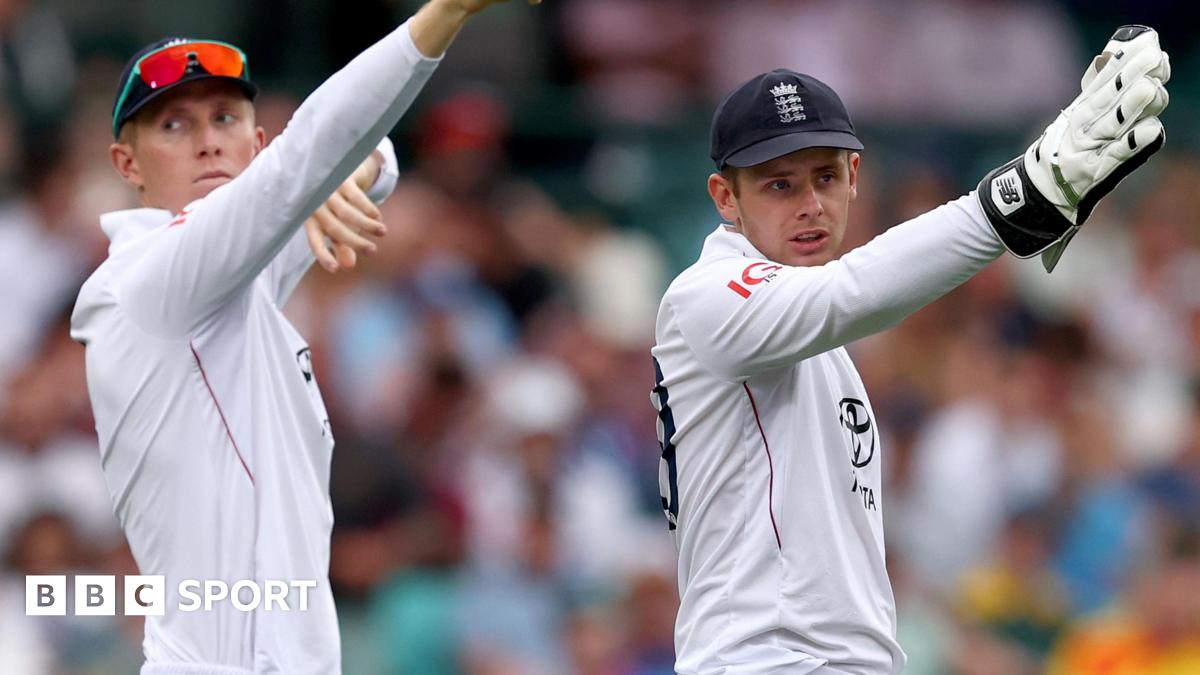 Zak Crawley on the left and wicketkeeper Jamie Smith on the right, both pointing with their right hands raised up at something off camera during the Sydney Test match