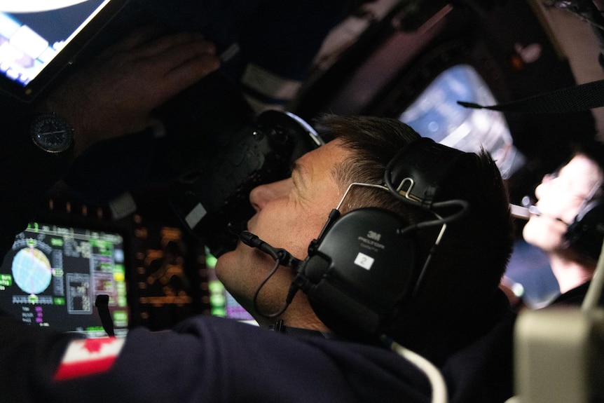 Mission Specialist Jeremy Hansen is seen taking images through the Orion spacecraft window