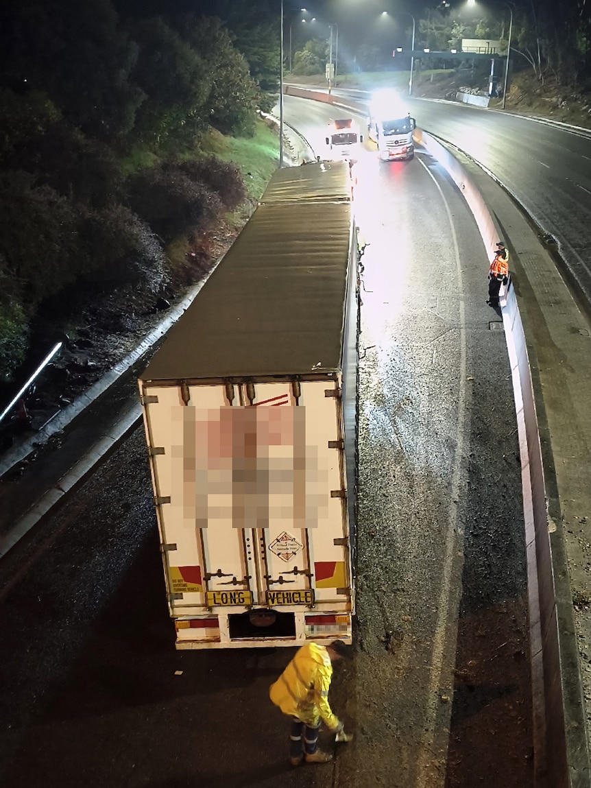 A b-double truck on an empty freeway lane at night