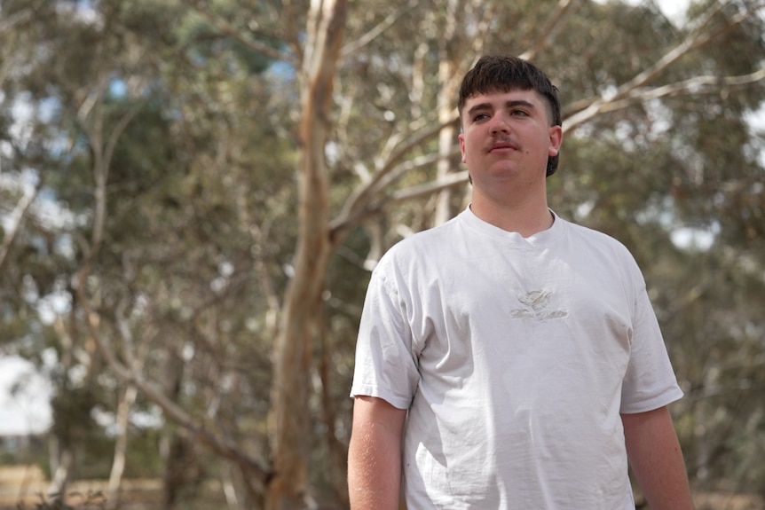 A young man looks to the side. 