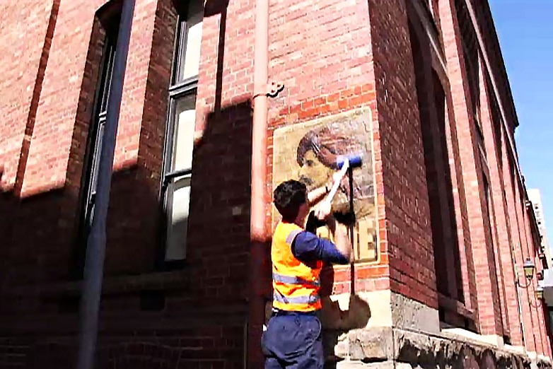 Peter Drew puts up a poster from his new project