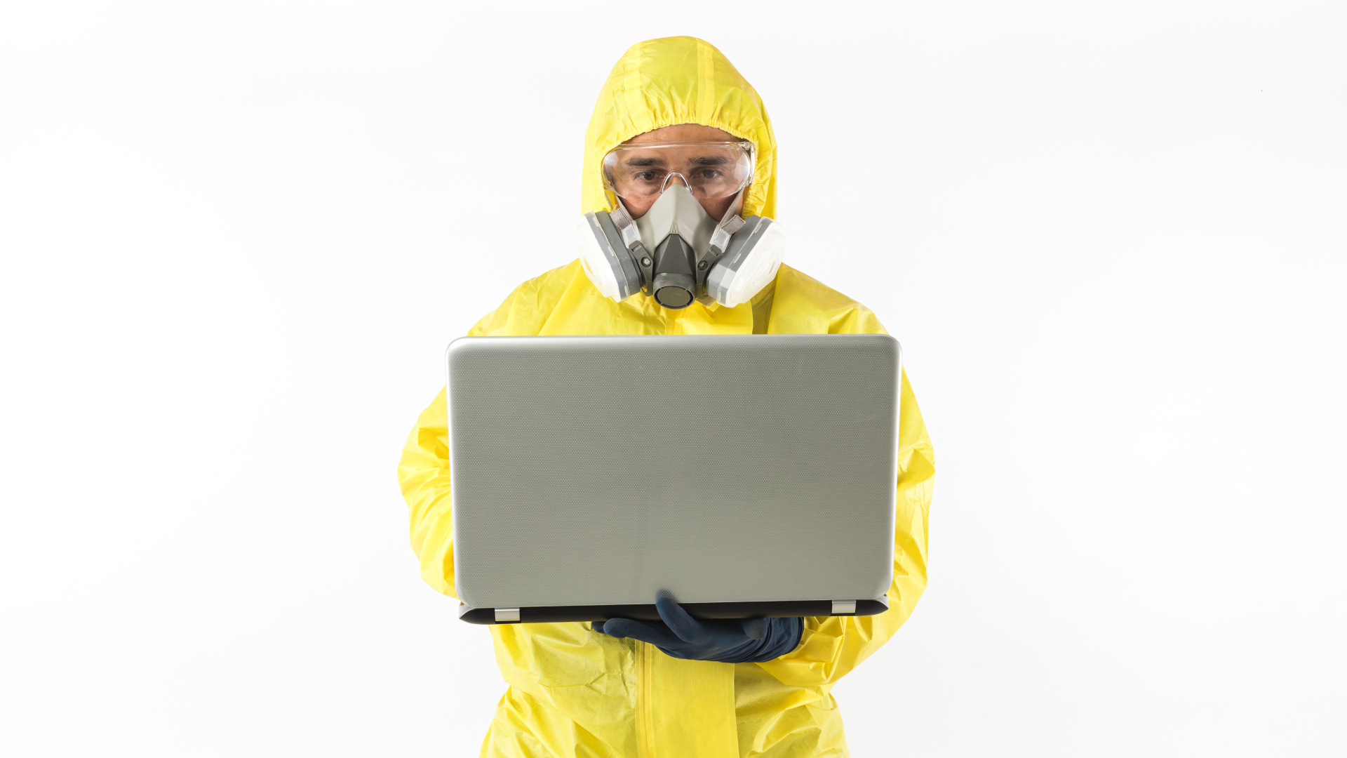 A man in a hazmat suit holding a laptop.