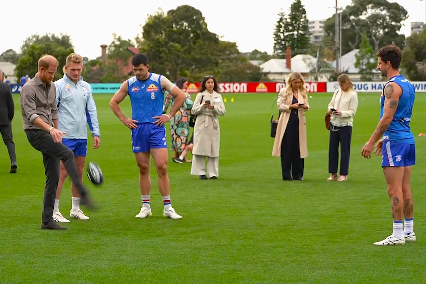 Prince Harry kicking a footy