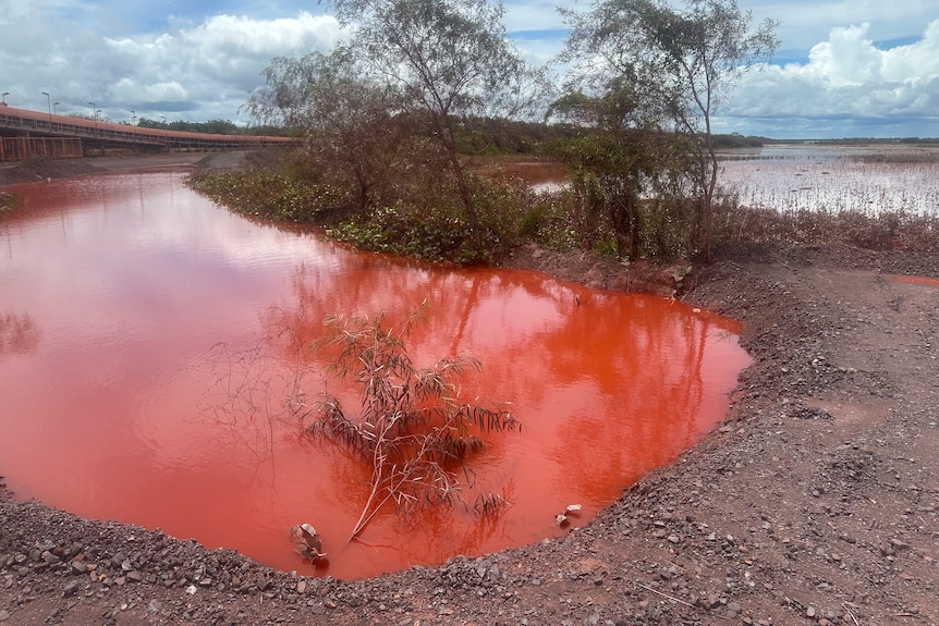 A pool of bright orange liquid into wider water source