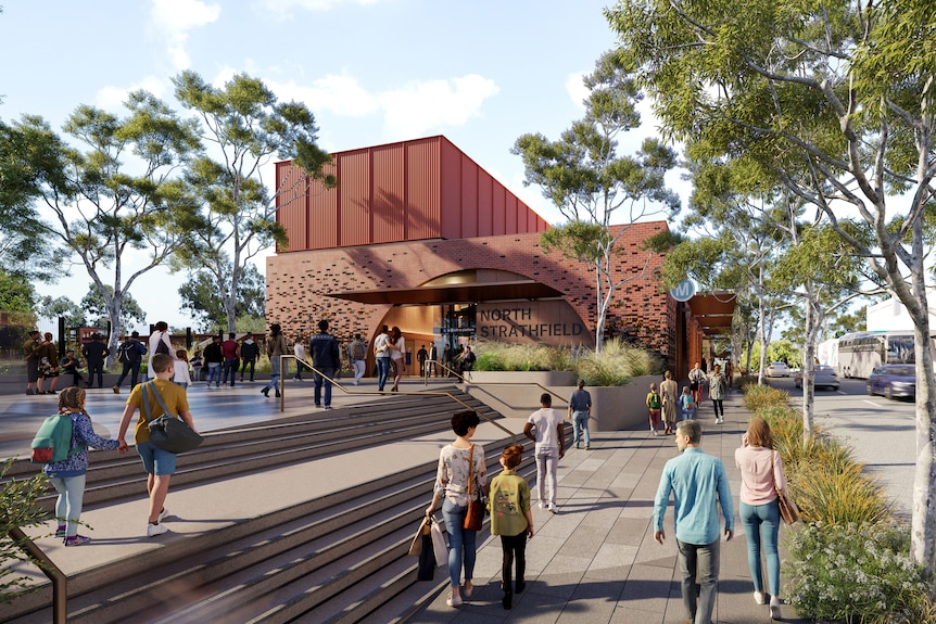 A red-brick building with steps leading up to it and a few trees nearby. The entryway is an arch.