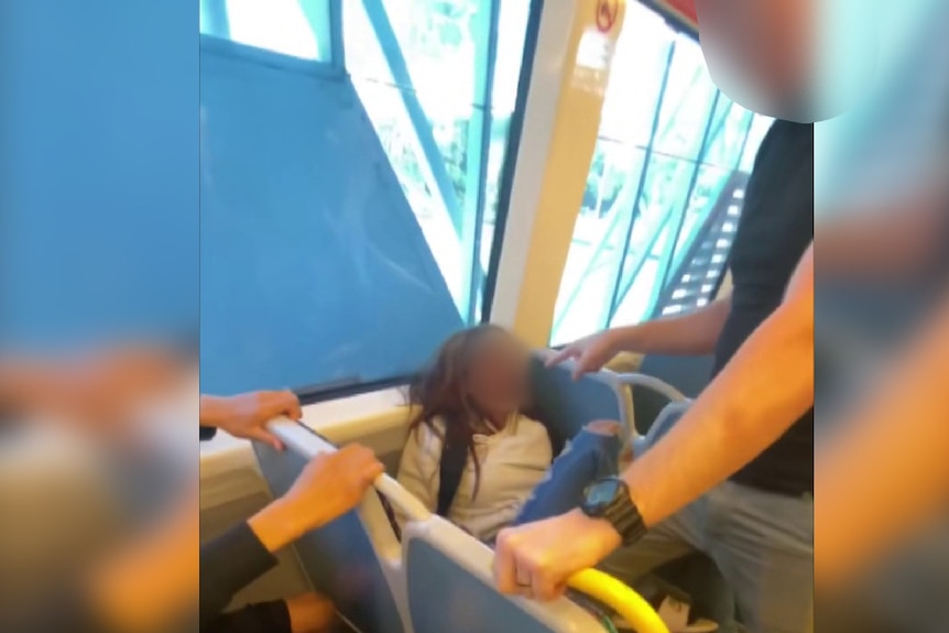 A young girl appears to have knocked her head against the hard plastic shell of the train window frame. 