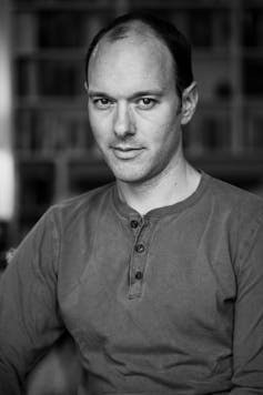 a man in a buttoned long sleeved t-shirt