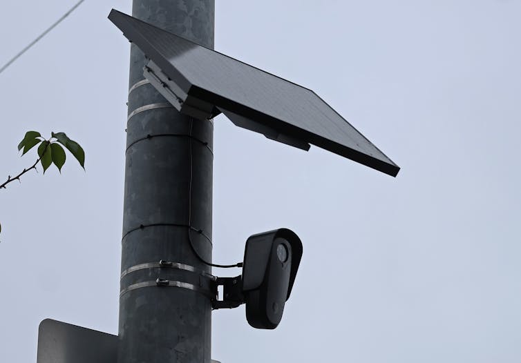A camera and solar panel attached to a traffic pole