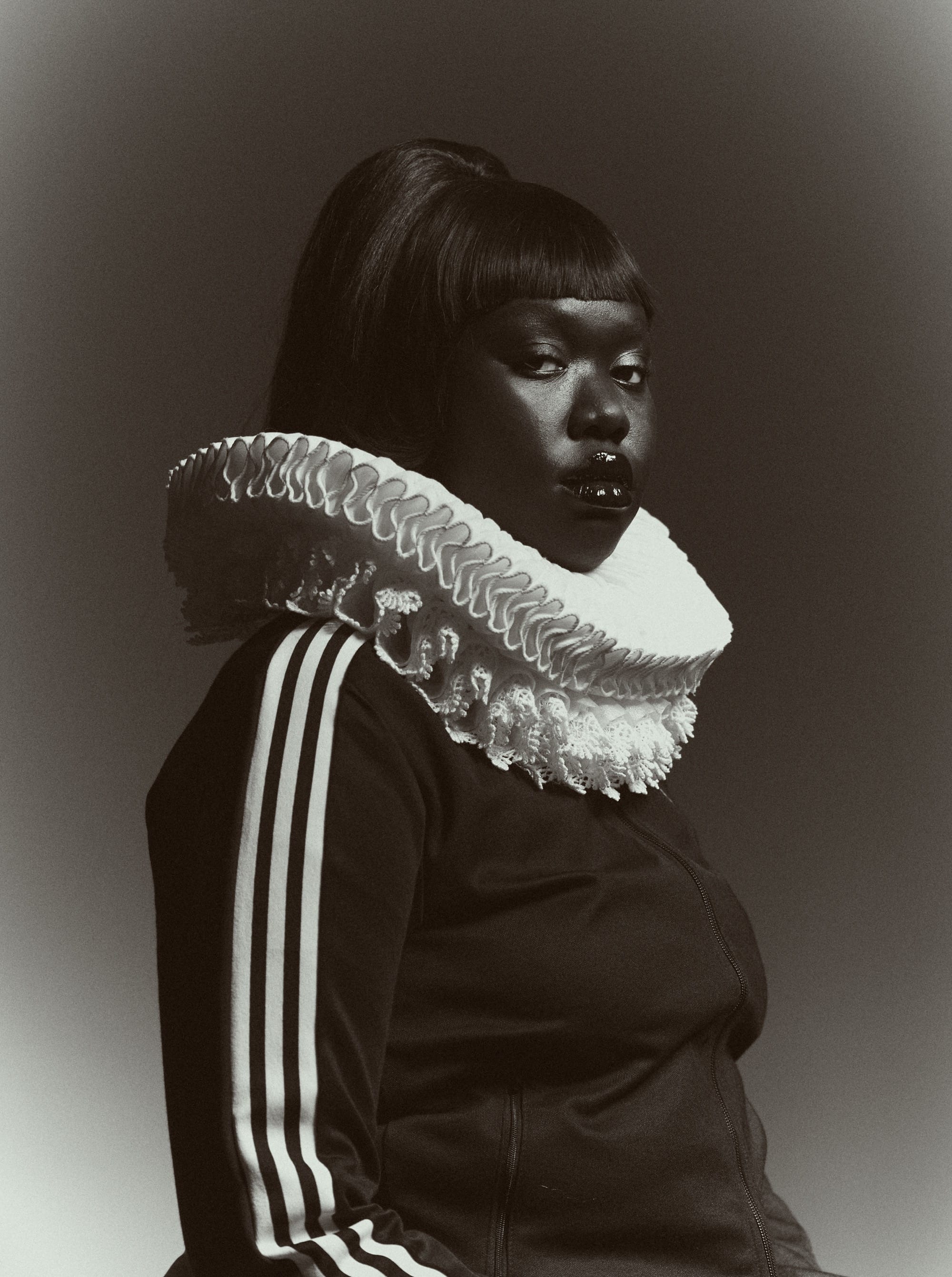a black and white photo by Austn Fischer of a woman in a tracksuit and frilly collar