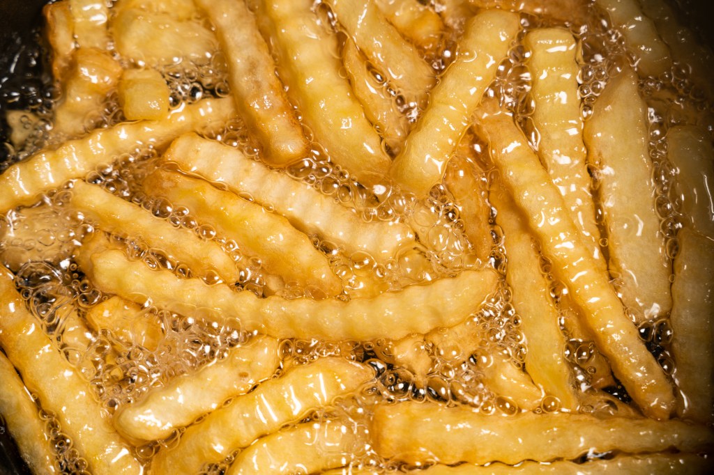 French fries cooking in a deep fryer.