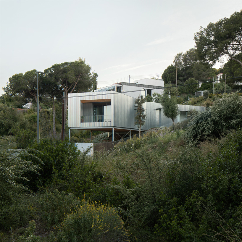 metallic house 144º rises on steel stilts above hillside near barcelona - 1