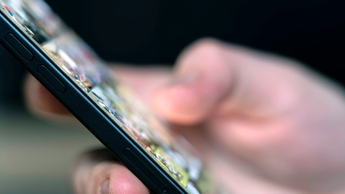 Person using an iPhone holding it in their hand