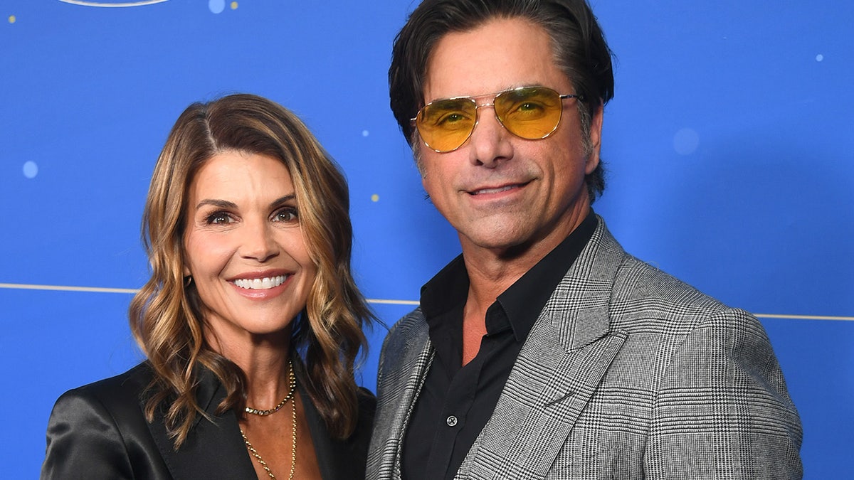 Lori Loughlin and John Stamos smiling at an event in Los Angeles