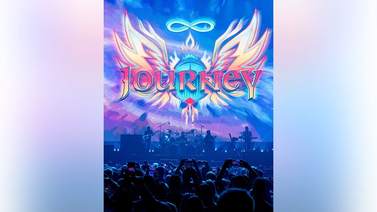Todd Jensen, Deen Castronovo, Neal Schon and Jason Derlatka of Journey performing on stage at Moody Center