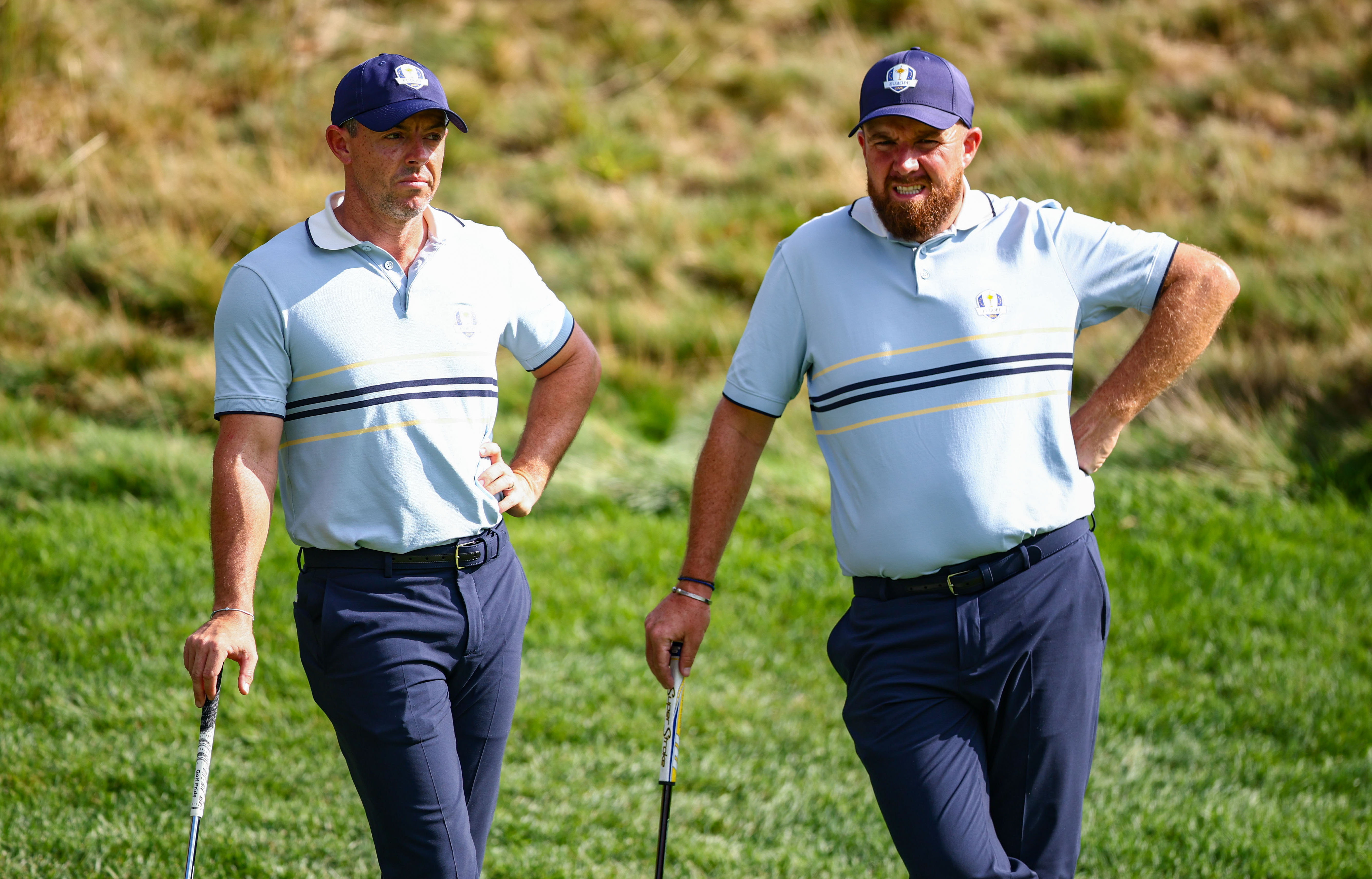 Rory McIlroy and Shane Lowry rest on their putters at the Ryder Cup