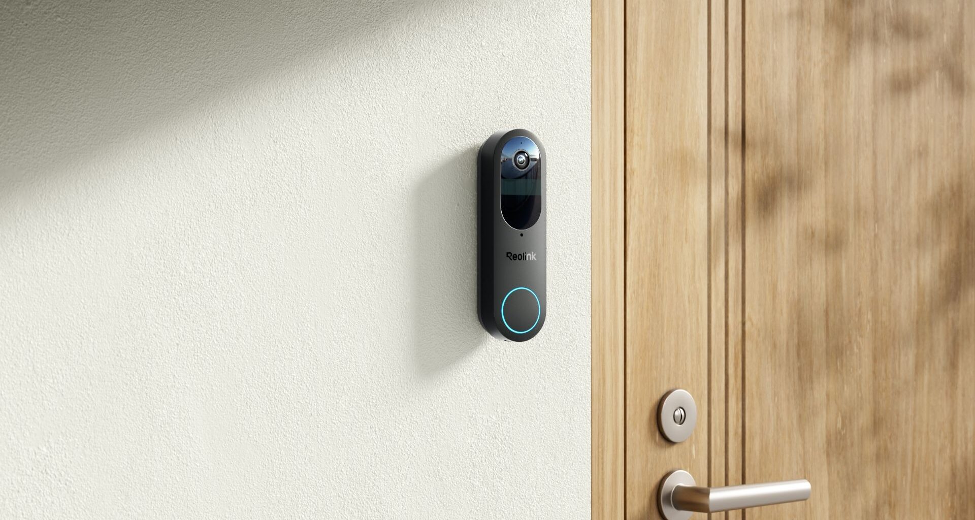 Reolink Battery Doorbell installed on a white wall next to wooden door