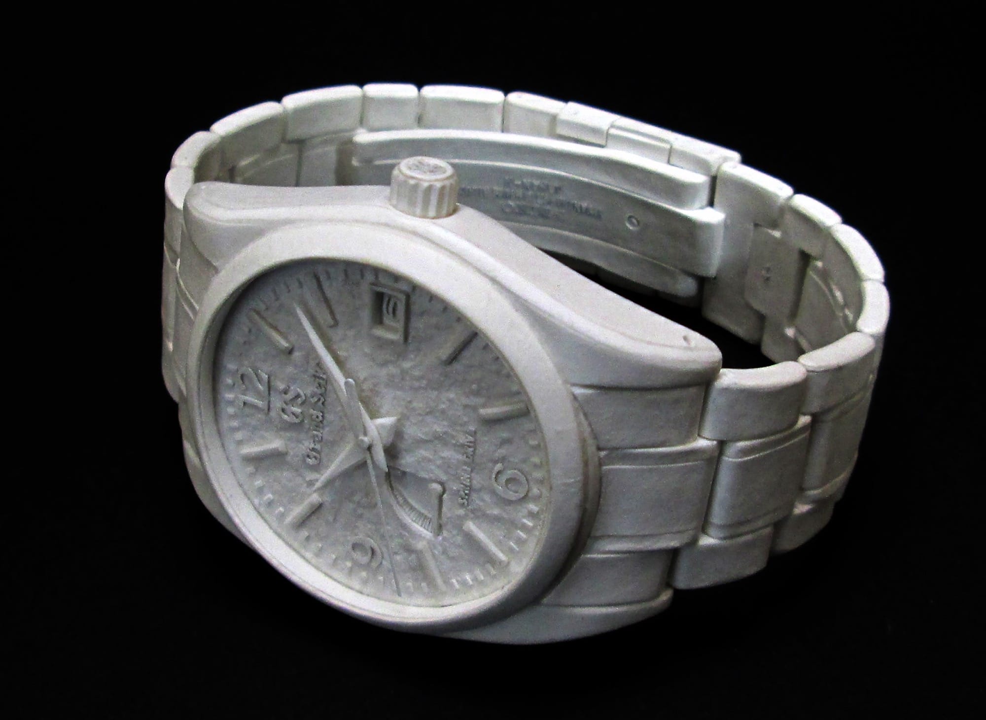 a hyperrealistic, scale sculpture of a watch made from white paper