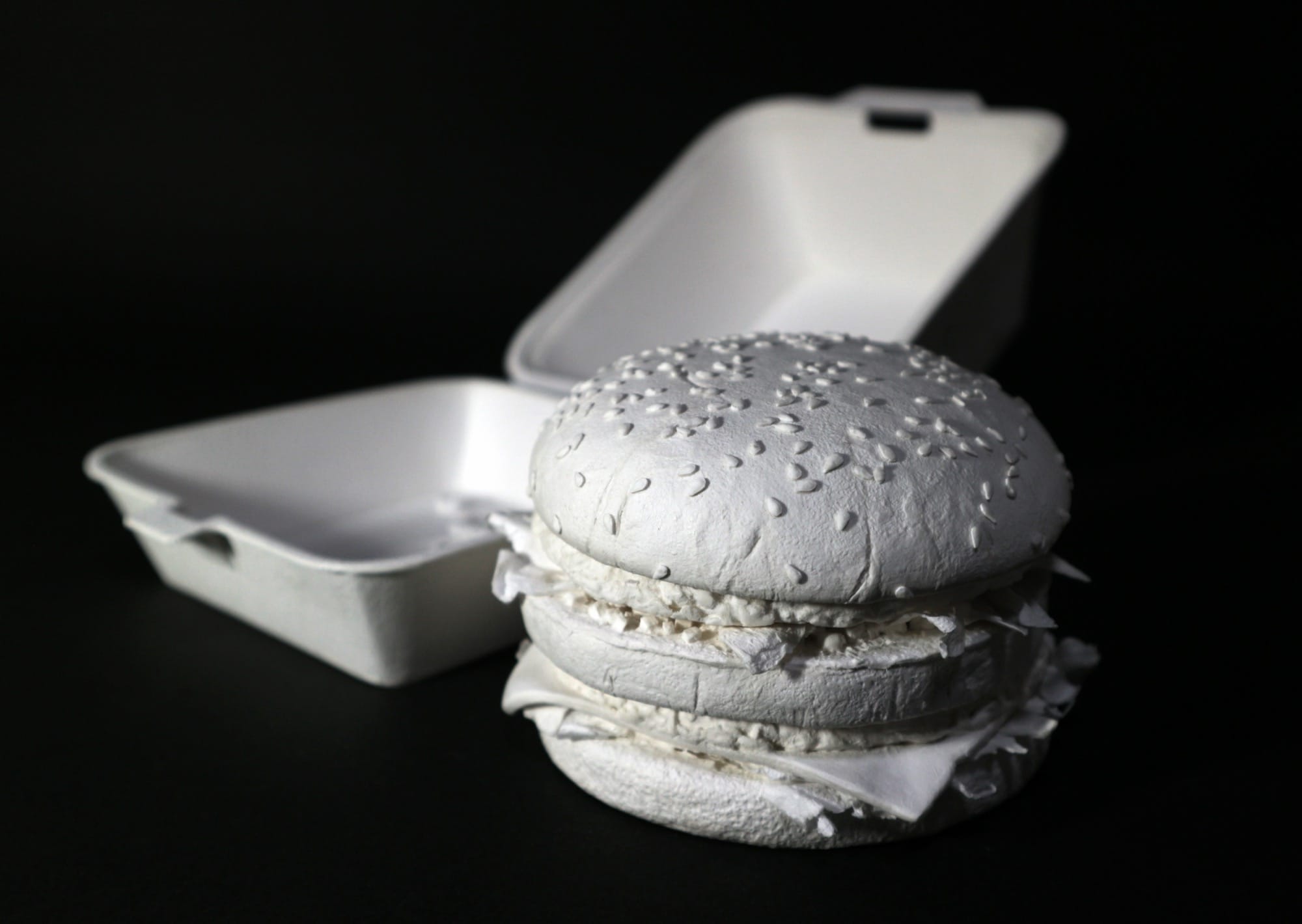 a hyperrealistic, scale sculpture of a Big Mac burger and its container made from white paper